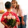 мальчик поздравляет маму цветами