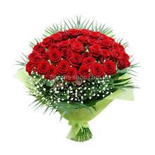 Букет в декоративной упаковке из красных роз, гипсофилы и листьев феникса