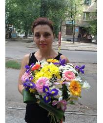 Пестрый букет из смешанных цветов в руках флориста