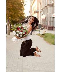 Девушка с цветами прыгает от радости