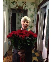 Женщина с букетом красных роз в момент доставки