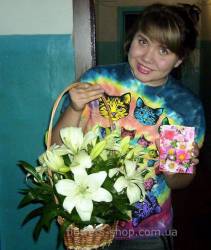 Basket with white lilies in the hands of the recipient Send flowers to Tyachev